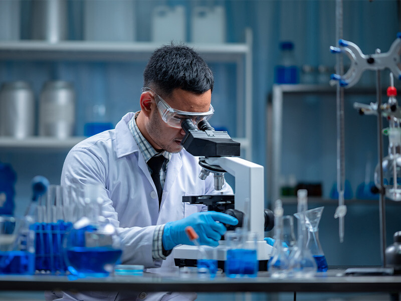 Male scientist looking through a microscope